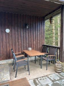 Une table et des chaises en bois sont disponibles sur la terrasse. dans l'établissement Ferienhaus Erinnerung, à Friedrichroda