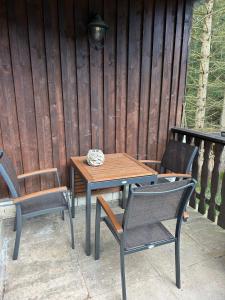 Une table et des chaises en bois sont disponibles sur la terrasse. dans l'établissement Ferienhaus Erinnerung, à Friedrichroda