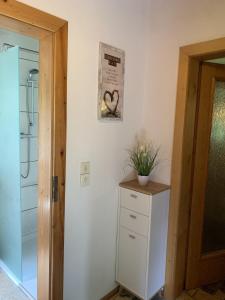 ein Badezimmer mit einem weißen Schrank und einer Tür in der Unterkunft Ferienhaus Erinnerung in Friedrichroda