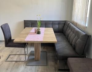 un divano in pelle con tavolo in legno e panca di Haus am Feistritz See a Feistritz ob Bleiburg