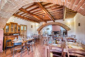 uma sala de jantar com mesas e cadeiras de madeira em Lavanda ad Antico Casale '700 em Umbertide