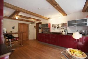 eine Küche mit roten Schränken und einer Schale Obst in der Unterkunft Ferienhaus in Riederau mit Großem Garten in Dießen am Ammersee