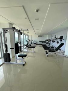a gym with several treadmills and chairs in a room at Cozy studio unit in a condominium in Iloilo City