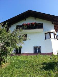 un edificio con una caja de ventanas con flores. en Ferienwohnung in ruhiger Lage am Waldrand - b55795, en Navis