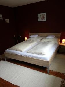 Schlafzimmer mit einem Bett mit weißer Bettwäsche und Kissen in der Unterkunft Ferienwohnung in ruhiger Lage am Waldrand - b55795 in Navis