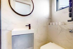 ein Bad mit einem Waschbecken und einem Spiegel in der Unterkunft 5Bed Home w Free Parking & Garden - 8min to tube in London