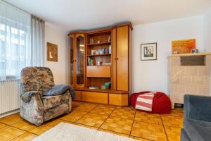 ein Wohnzimmer mit einem Stuhl und einem Bücherregal in der Unterkunft Ferienwohnung Schätzle in Schuttertal