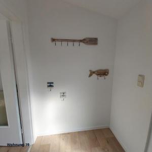 a room with a white wall with a shelf on it at Zeit für Erholung, Ferienhaus A&C Prudlo, Usedom in Lütow