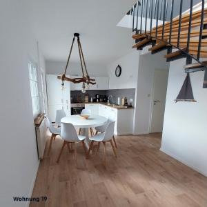 a kitchen and dining room with a white table and chairs at Zeit für Erholung, Ferienhaus A&C Prudlo, Usedom in Lütow