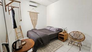 a bedroom with a bed and a table and a chair at Oke Baik Hostel in Yogyakarta