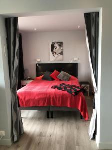 um quarto com uma cama vermelha e um cobertor vermelho em Cap d' Agde Naturiste Héliopolis F31 em Cap d'Agde