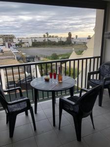een tafel met twee glazen wijn op een balkon bij Cap d' Agde Naturiste Héliopolis F31 in Cap d'Agde