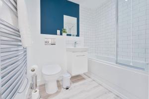 een witte badkamer met een toilet en een wastafel bij Lovely 1 Bed Apartment Nightingale Quarter Derby in Derby