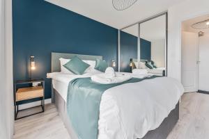 een slaapkamer met een groot bed met blauwe muren bij Lovely 1 Bed Apartment Nightingale Quarter Derby in Derby