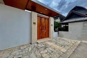 una porta di legno sul lato di una casa di Belvilla 93823 Villa Gan Near Titi Batu Club Ubud ad Ubud