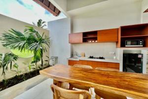 una cucina con tavolo in legno e alcune piante di Belvilla 93823 Villa Gan Near Titi Batu Club Ubud ad Ubud