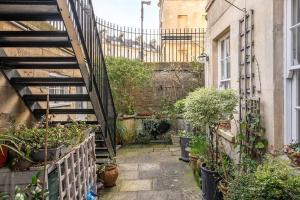 a small garden with potted plants and a staircase at Beautiful Basement Apartment in Bath