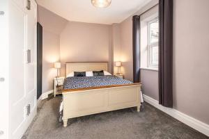 um quarto com uma cama com 2 candeeiros e uma janela em Beautiful Basement Apartment em Bath