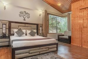 a bedroom with a bed and a chair and a window at THE BLISSFUL BREEZE VILLA KASAULI BY EXOTIC STAYS in Kasauli