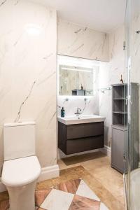 a white bathroom with a toilet and a sink at Beautiful Basement Apartment in Bath