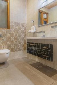 a bathroom with a toilet and a sink and a mirror at THE BLISSFUL BREEZE VILLA KASAULI BY EXOTIC STAYS in Kasauli