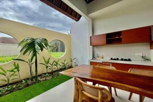 a kitchen with a wooden table and a palm tree mural at Belvilla 93824 Villa Nesa Near Titi Batu Club Ubud in Ubud