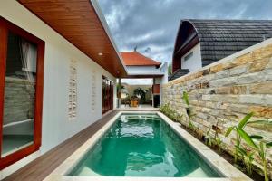 a swimming pool in the backyard of a house at Belvilla 93824 Villa Nesa Near Titi Batu Club Ubud in Ubud