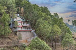 a house on a hill in the middle of a forest at THE BLISSFUL BREEZE VILLA KASAULI BY EXOTIC STAYS in Kasauli