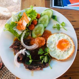 um prato de comida com um ovo e uma salada em Sunrise Dốc Lết em Ninh Hai