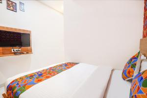a bedroom with a white bed with a window at FabHotel Prime Lotus in Vadodara