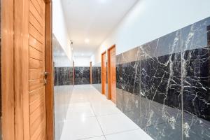 a hallway with a black marble wall at FabHotel Prime Lotus in Vadodara