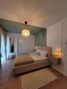 a bedroom with a large bed and a chandelier at Pensiunea Coralia in Deva +70 photos