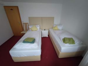 two beds sitting next to each other in a room at Room in Guest room - Pension Forelle - double room 01 in Forbach