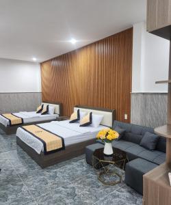 Habitación de hotel con 2 camas y sofá en HOTEL SONG TIÊN, en Trà Vinh