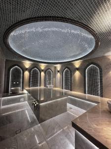 uma grande casa de banho com um tecto grande e uma grande banheira em Ziyorat Luxury em Fergana