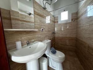 uma casa de banho com um lavatório e um WC em Skiathos Hills Studios em Skiathos Town