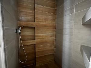 uma casa de banho com um chuveiro e uma parede de madeira em Skiathos Hills Studios em Skiathos Town
