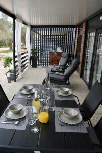 a wooden table with plates and glasses on a patio at Mobile home Anita in Sveti Petar
