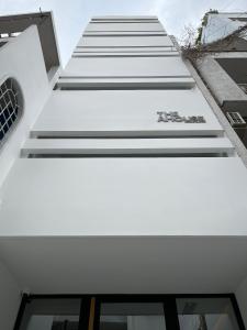 een witte gevel van een gebouw met ramen bij The AHouse High-End Interior Design Building in Ho Chi Minh-stad