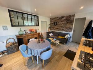 a living room with a table and chairs and a couch at Petite maison dans la manche in Créances