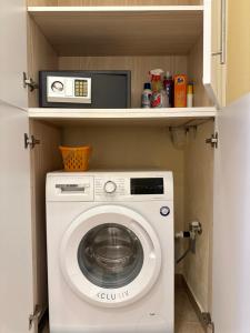 a kitchen with a washing machine and a microwave at Simple Pleasure Verde Blu App in Barbati
