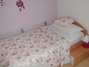 een slaapkamer met een bed met een bloemdekbed bij Appartement in Burg Auf Fehmarn mit Terrasse, Garten und Grill in Fehmarn