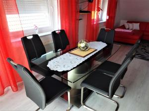 een eettafel en stoelen met rode gordijnen bij Appartement in Burg Auf Fehmarn mit Terrasse, Garten und Grill in Fehmarn