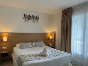 ein Hotelzimmer mit einem Bett mit ausgestopftem Tier darauf in der Unterkunft Best Western Hotel & Spa Austria-La Terrasse in Saint-Étienne