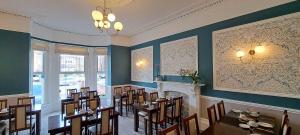 a dining room with tables and chairs and a fireplace at Victoria Park Lodge & Serviced Apartments in Leamington Spa