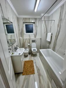 a bathroom with a sink and a toilet and a tub at Ares Residence in Iaşi