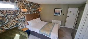 a small bedroom with a bed and a wall at Victoria Park Lodge & Serviced Apartments in Leamington Spa