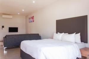 1 dormitorio con 1 cama blanca grande y 1 sofá en Cherrywood Estate Apartment en Blantyre