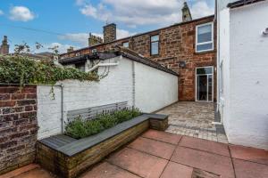 a brick building with a bench in front of it at 58 Prestwick Road in Ayr