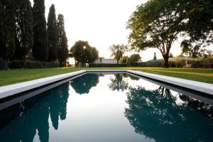 una piscina in un cortile alberato e un campo di VILLA SACCOMANI a Sommacampagna
